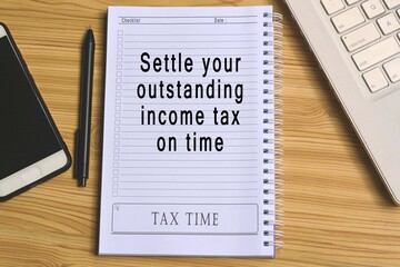 Text on notepad with laptop and smartphone on wooden table