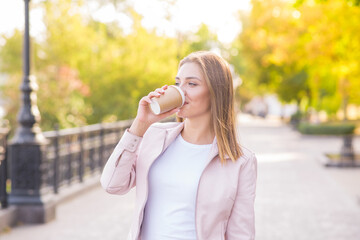 Portrait of a young, happy and pretty blonde girl with a cup of coffee in her hands