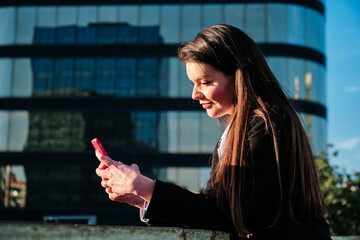 Business woman using her phone outdoors.