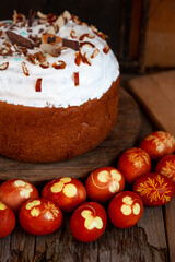 Easter cake and colored eggs. Rustic food on a wooden table. Egg colored with onion peel. Clover and dill leaves pattern. Classic food for the Easter holiday
