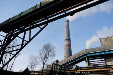 Obraz premium Almaty, Kazakhstan - 02.04.2021 : Metal structure on the background of a smoking pipe of a heating plant