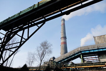 Obraz premium Almaty, Kazakhstan - 02.04.2021 : Metal structure on the background of a smoking pipe of a heating plant