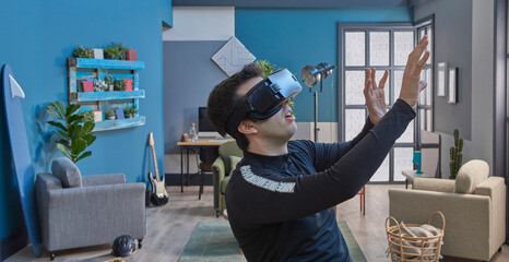 Close up man with virtual reality goggles, decorative blue wall background.