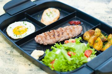 Breakfast, fried steak or cutlet, salad with tomato and green vegetables, toast, potato, egg closeup, light background. Concept healthy eating, diet, menu, nutritious food.