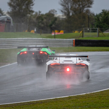 A Shot Of Several Racing Cars As They Circuit A Track.