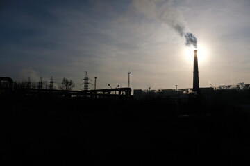 Almaty, Kazakhstan - 02.04.2021 : Silhouette of building, heating plant with Smoking chimneys
