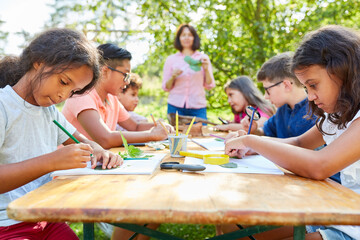 Kinder im Sommercamp beim zeichnen und basteln