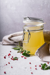 selective focus. Homemade Beef Bone Broth in a glass jar. on a light gray background. with the addition of spices-salt and pepper. Bones contain collagen, which provides the body with amino acids