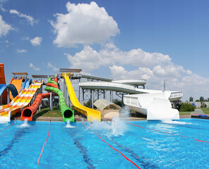 Water park, bright multi-colored slides with a pool. A water park without people on a summer day
