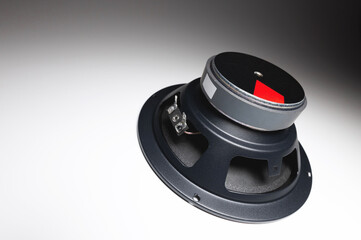 New car audio speaker. One loudspeaker on gray background