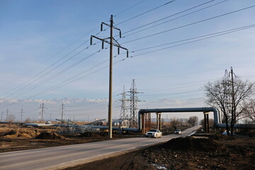 Obraz premium Almaty, Kazakhstan - 02.04.2021 : The road along the power lines and pipes of the heating plant