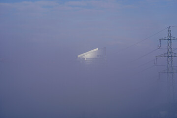 Fototapeta na wymiar Top of skyscraper in the sky with thick fog.
