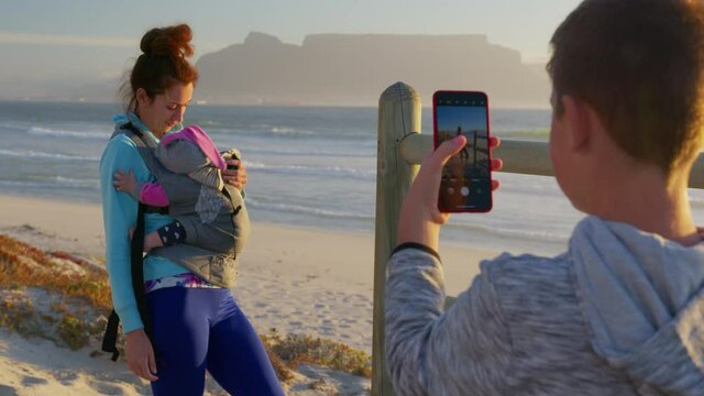 Son photographs mom and child against the backdrop of the table mountain at sunset, South Africa.