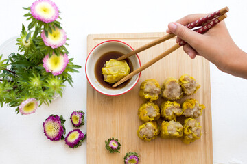 hand of girl clamping dumpling chinese snack foods china arrangement on block flat lay style on background white 