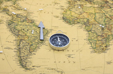 Classic round compass on background of old vintage map of world as symbol of tourism with compass, travel with compass and outdoor activities with compass