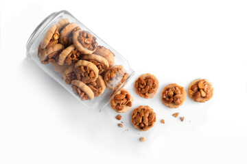 Homemade peanut butter cookies in a glass jar on white background, top view