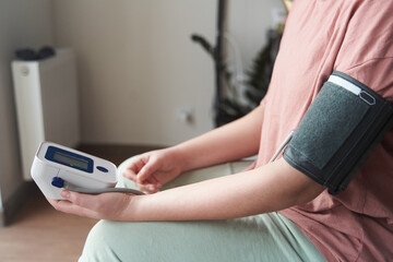 Fototapeta premium Selective focus girl is taking care for health with hearth beat monitor and blood pressure and heart rate monitor with digital pressure gauge. Health care and Medical concept. The topic of high blood