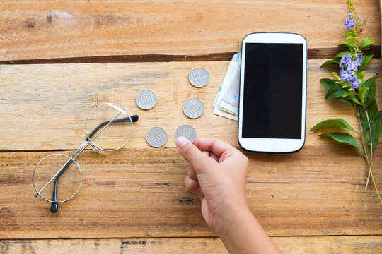 Handle Of Girl Count Coins With Cash ,coins ,mobile Phone Of Lifestyle A Girl Arrangement Flay Lay Style On Background Wooden