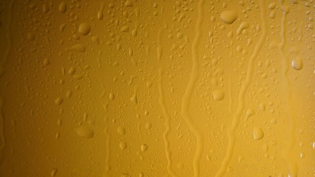Cold beer in a glass bottle with dripping condensation drops. Beer background with drops of cold water condensate