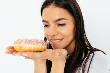 Close-up portrait of happy smiling young woman looking at delicious donut