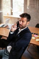 Businessman in conference room using the phone. Handsome businessman talking to the phone..