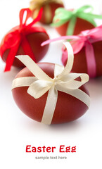 Easter egg with colored ribbon on the white background