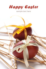 Easter eggs with ribbon on the ears of wheat on the white background