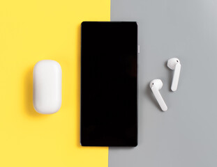 Smartphone and white wireless earphones