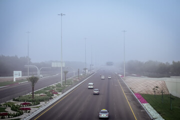 Road in the fog, sign mention keep distance for motorists at dubai road, foggy weather in UAE, Dense Fog keep Safe Distance banner in arabic and english