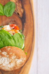 Burger with king prawn, feta cheese and vegetables, on a wooden board