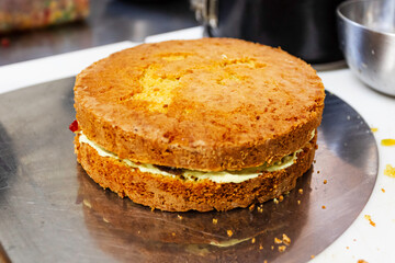 Confectioner decorating delicious cake in pastry shop