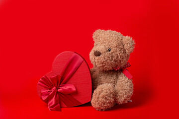 teddy bear heart shaped box on red background valentine's day