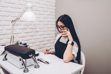 Businesswoman, conducts an appointment for a manicure procedure in a beauty salon. Business lady...