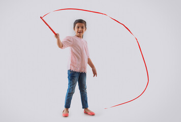 young girl playing with a ribbon wand	