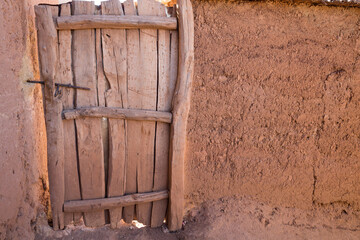 Old wooden door and adobe wall