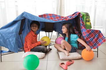 brother and sister camping at home	