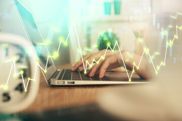 Double exposure of woman hands typing on computer and forex chart hologram drawing. Stock market invest concept.