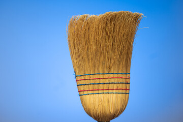 Braided broom close up detail shot isolated on blue background