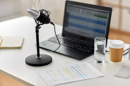 post production, podcast and technology concept - microphone and sound editor program on laptop computer at office