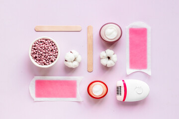 Set of epilation means - epilator with wax strips, razor and flowers. Top view