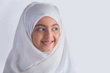 Young Muslim girl wearing hijab and looking away	