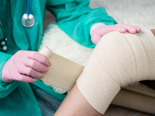 Close-up Applying a healing ointment to a bruise on the leg. Family doctor examines leg injury