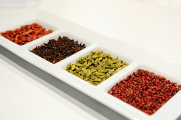 Spices placed in a white plate waiting to be used in the kitchen. Product photography.