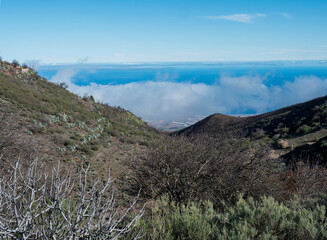 View of Beautiful Gran Canaria landscape from a hill with clouds and Atlantic ocean in the background. Canary island, Spain