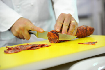 A chef's hands while slicing a dish.