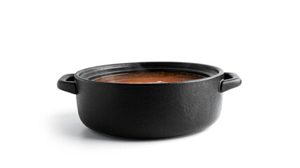 Hot soup in a black pot isolated on a white background.