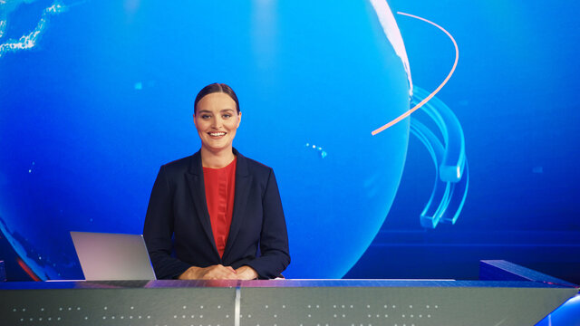 Live News Studio With Professional Female Newscaster Reporting On The Events Of The Day. Broadcasting Channel With Presenter, Anchor Smiling On Camera. Mock-up TV Newsroom Set.