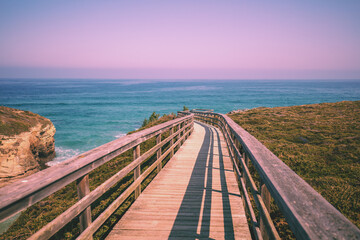 Fototapeta premium Wooden walkway on the rocky seashore. Photon viewpoint (Miradoiro de Foton) near Cathedrals Beach