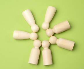 wooden figurines in the shape of a man lie on a green background