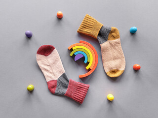 Odd Socks Day. Mismatched socks, wooden rainbow and toy figures. Social initiative against bullying...